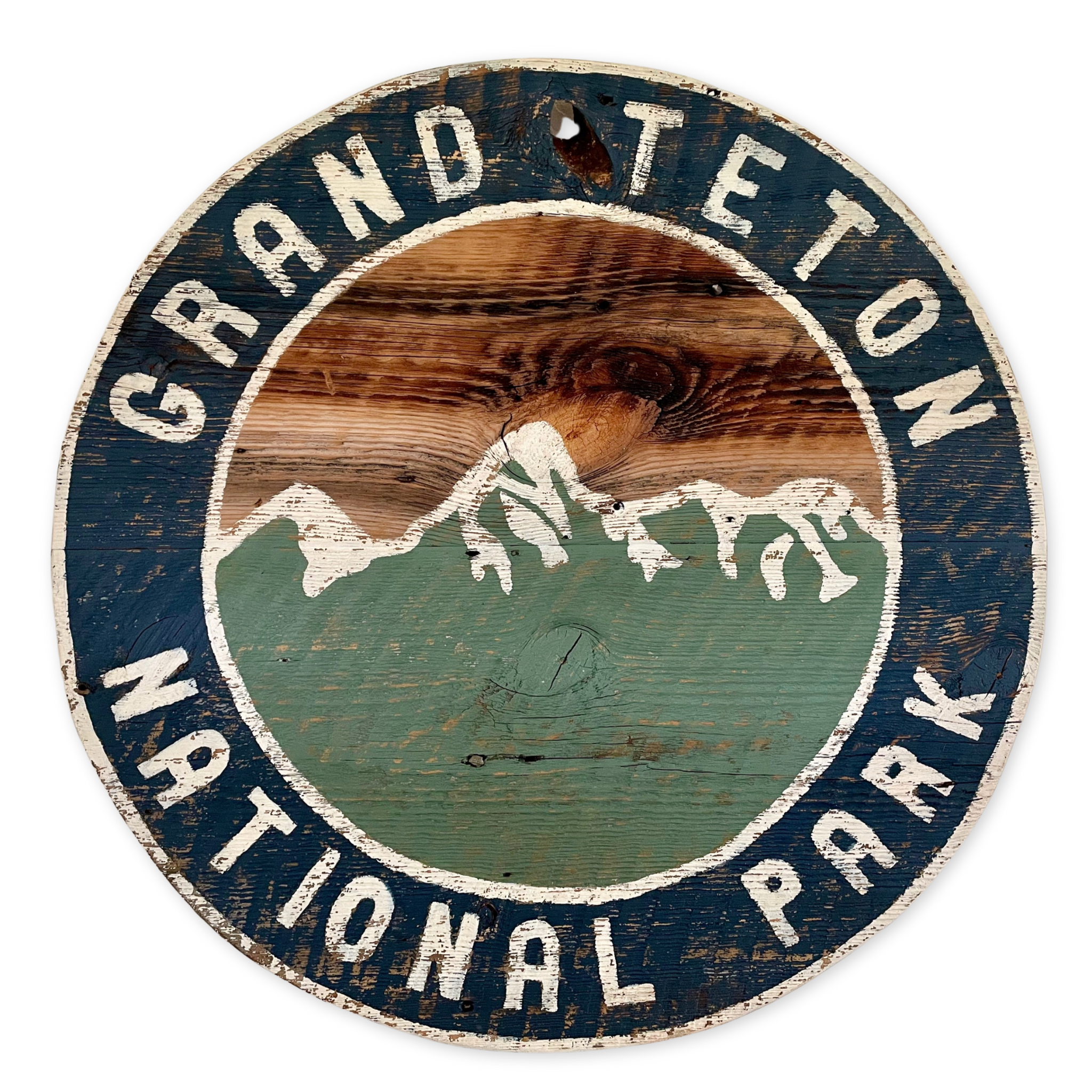 round wooden rustic inspired grand teton national park sign with an image of the tetons
