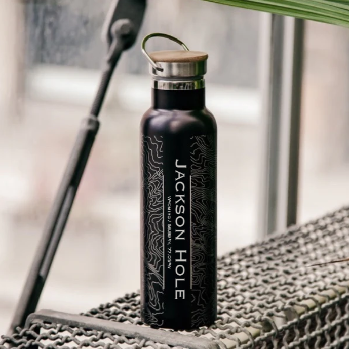 Topographical map of Jackson Hole on a black insulated water bottle with a bamboo lid. 