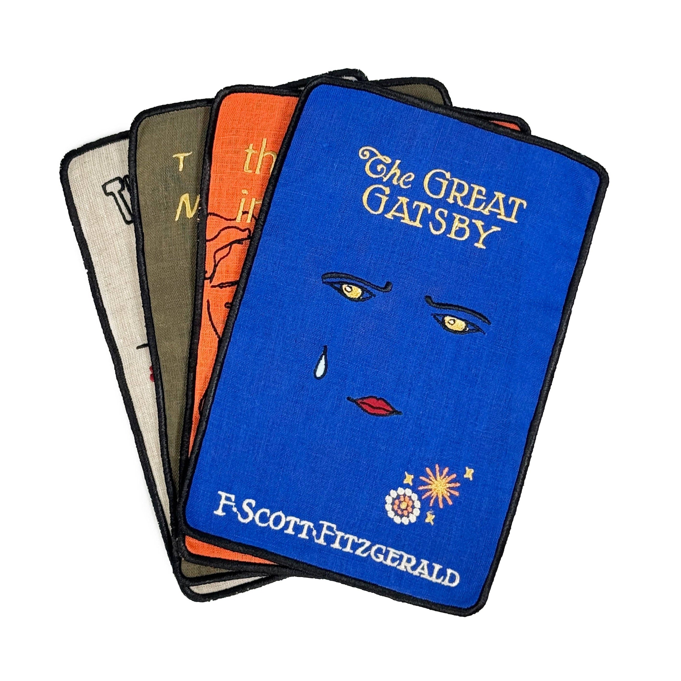 Stack of 'The Great Gatsby' book covers with a blue cover featuring a face design.