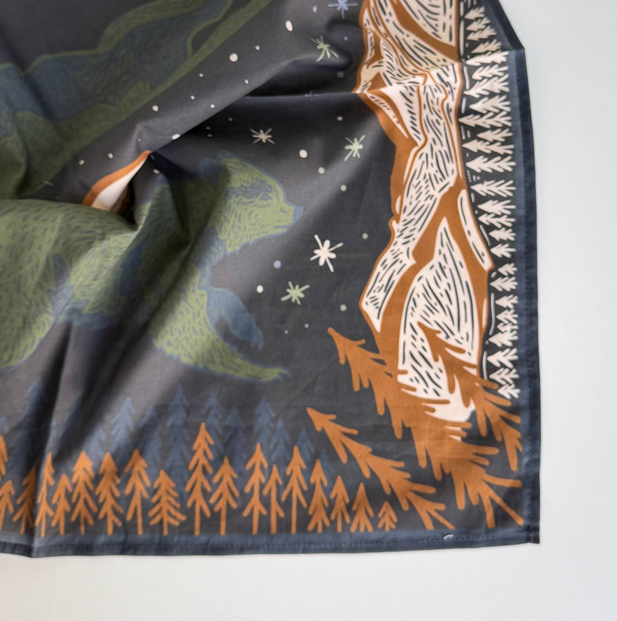 A square scarf featuring a detailed forest and night sky print in muted green, brown, and white on a dark navy background.