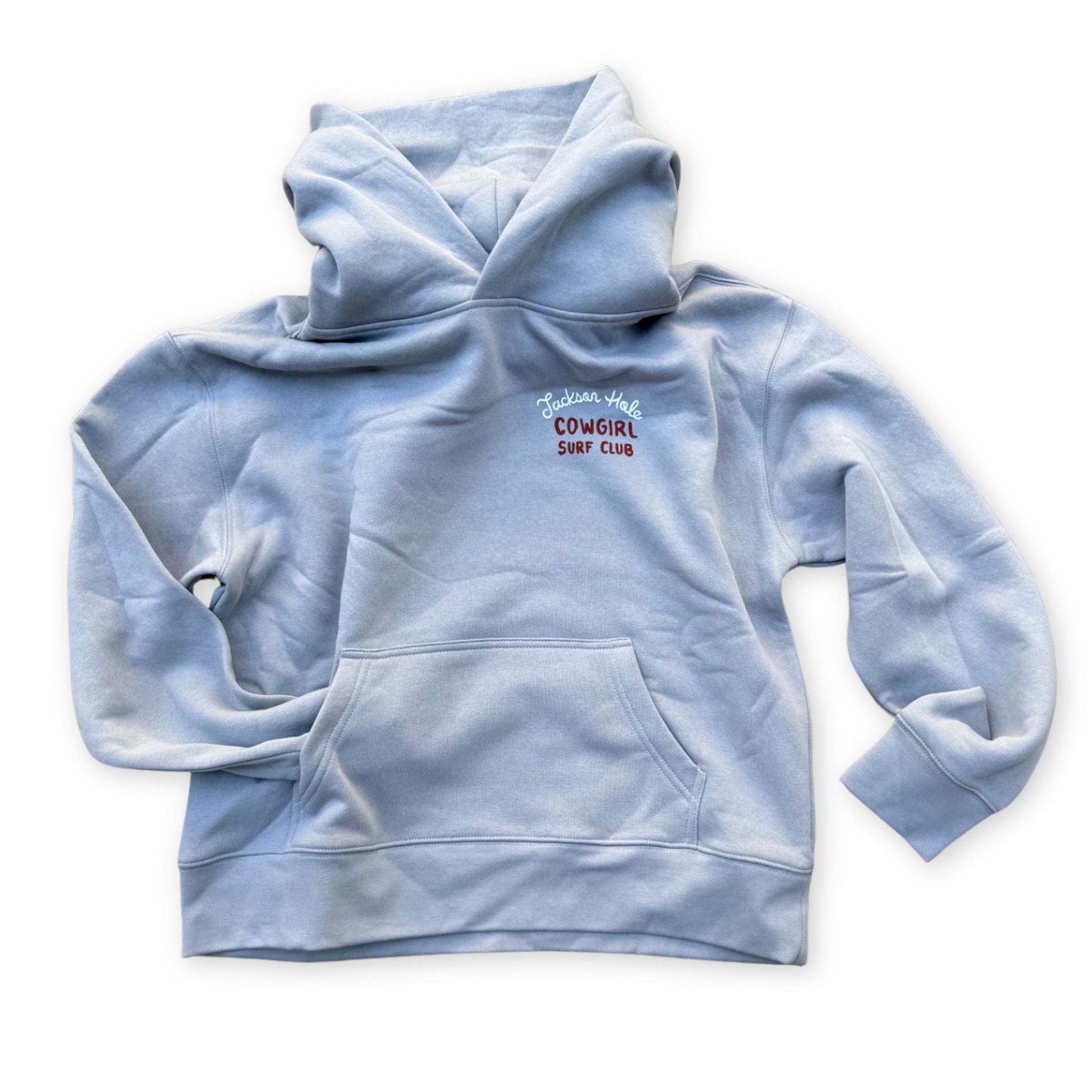 A light blue pullover hoodie with a small red and white 'Cowgirl Surf Club' graphic on the left chest.