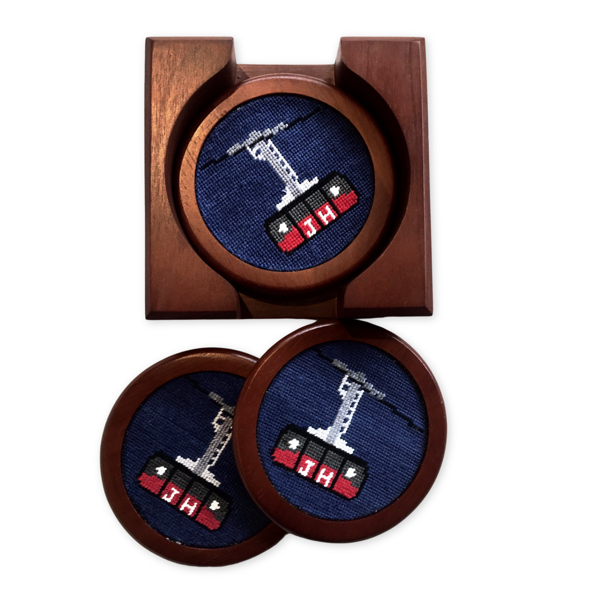 set of four needlepoint and wood coasters with the tram design in a wooden case