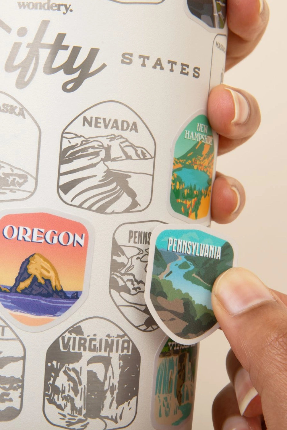 Sticker with state designs held by a hand, featuring Nevada, New Hampshire, Oregon, and Pennsylvania.
