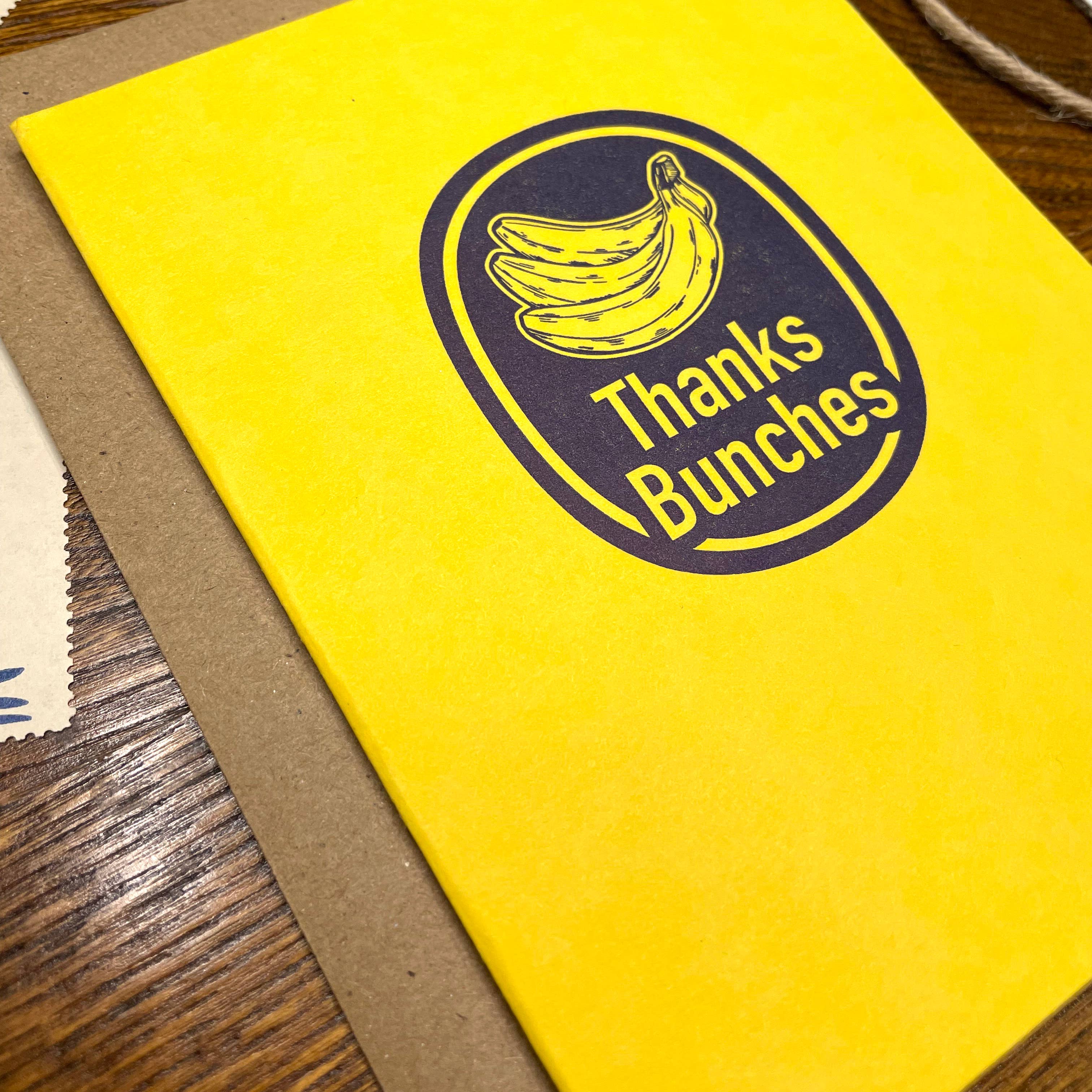 Yellow card with 'Thanks Bunches' design featuring bananas on a wooden surface